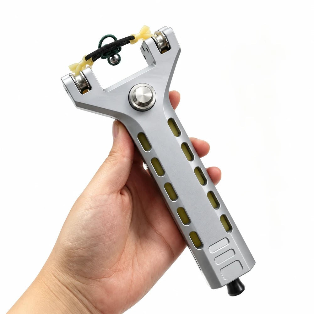 A hand holding the SLYNGR precision slingshot against a plain background.